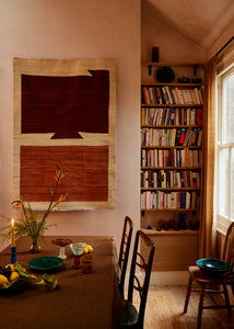 brown and creme Afghan handwoven wool rug hanging in dining room