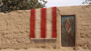 red and white striped handwoven Afghan wool rug hanging